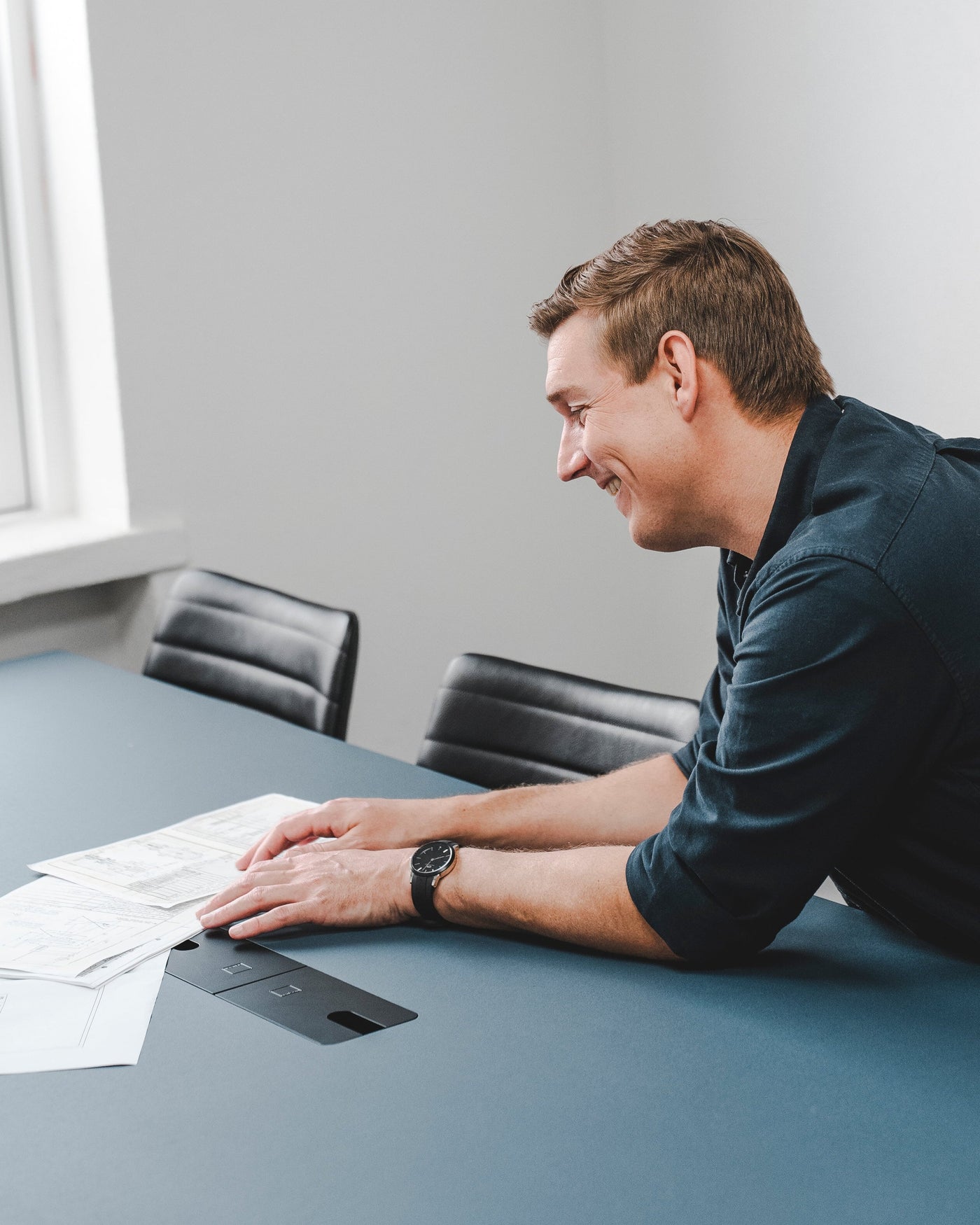 International Procurement Service employee showing papers in a meeting room.
