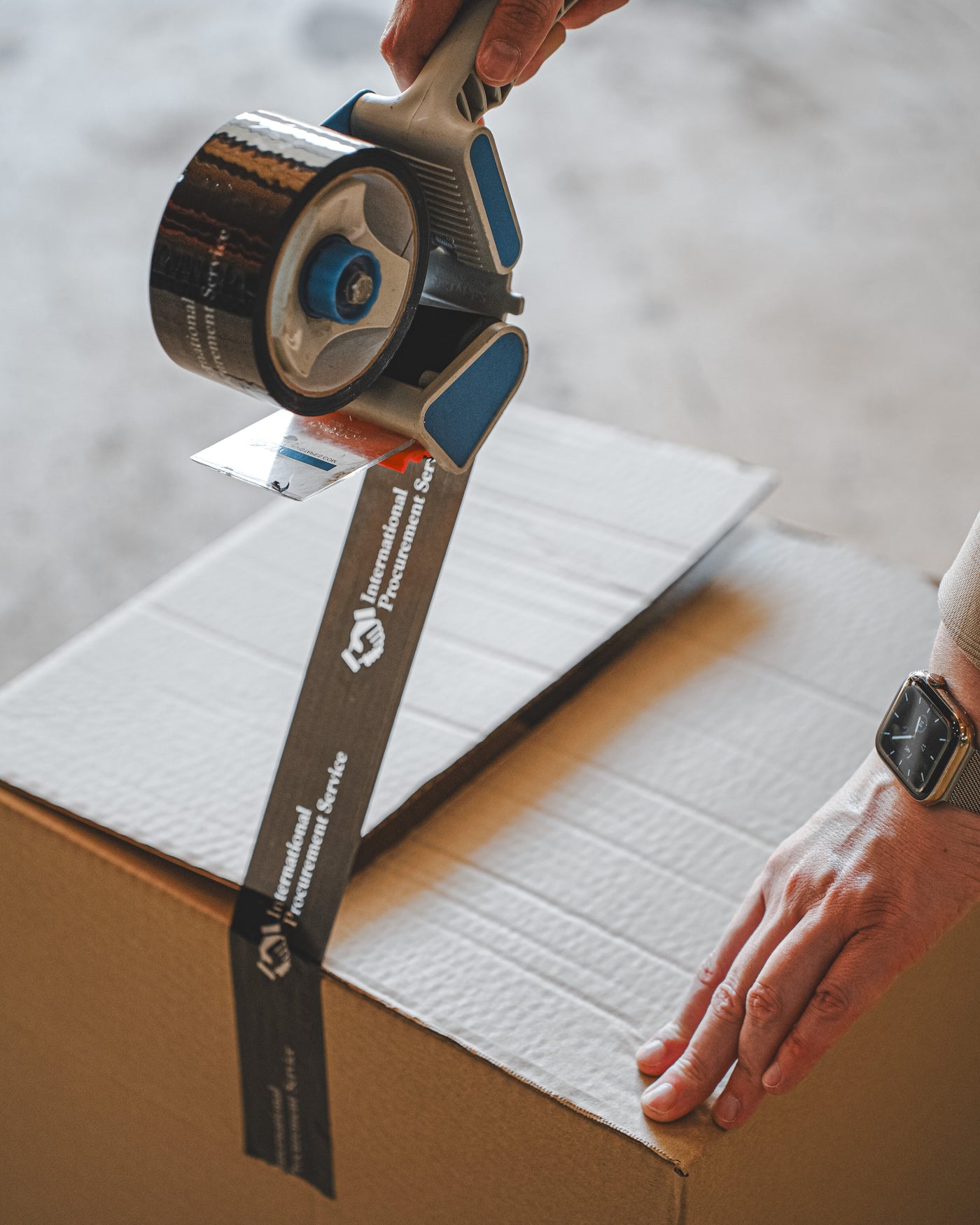 A package being sealed with International Procurement Service tape.