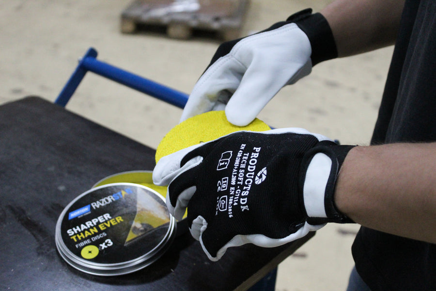 Worker wearing working gloves handling abrasives.